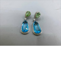 These dangling earrings are distinguished by pear-shaped peridot green crystals.