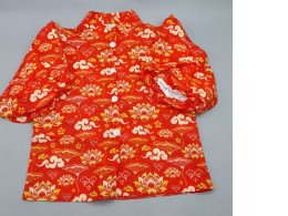 Red long-sleeved shirt with traditional pattern.