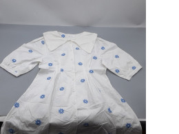 white dress featuring blue flower embroidery and a large collar. white dress featuring blue flower embroidery and a large collar.