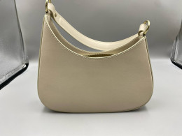 Beige shoulder bag, semi-circular shape, with zipper closure.