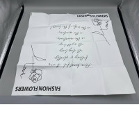 White gift wrapping paper decorated with a floral pattern.