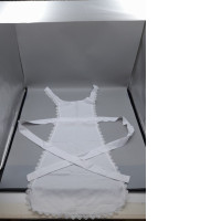 white cotton apron designed in a Victorian or maid costume style with decorative lace trim. 