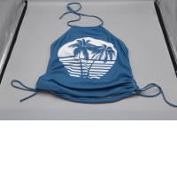 blue halter tankini top features a white graphic of palm trees over a striped horizon and has adjustable side-tie details. blue halter tankini top features a white graphic of palm trees over a striped horizon and has adjustable side-tie details.