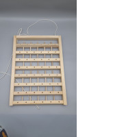 A wall-mounted wooden thread rack, commonly used for storing spools of sewing thread.