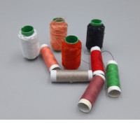 Set of 9 multi-colored sewing thread spools. 